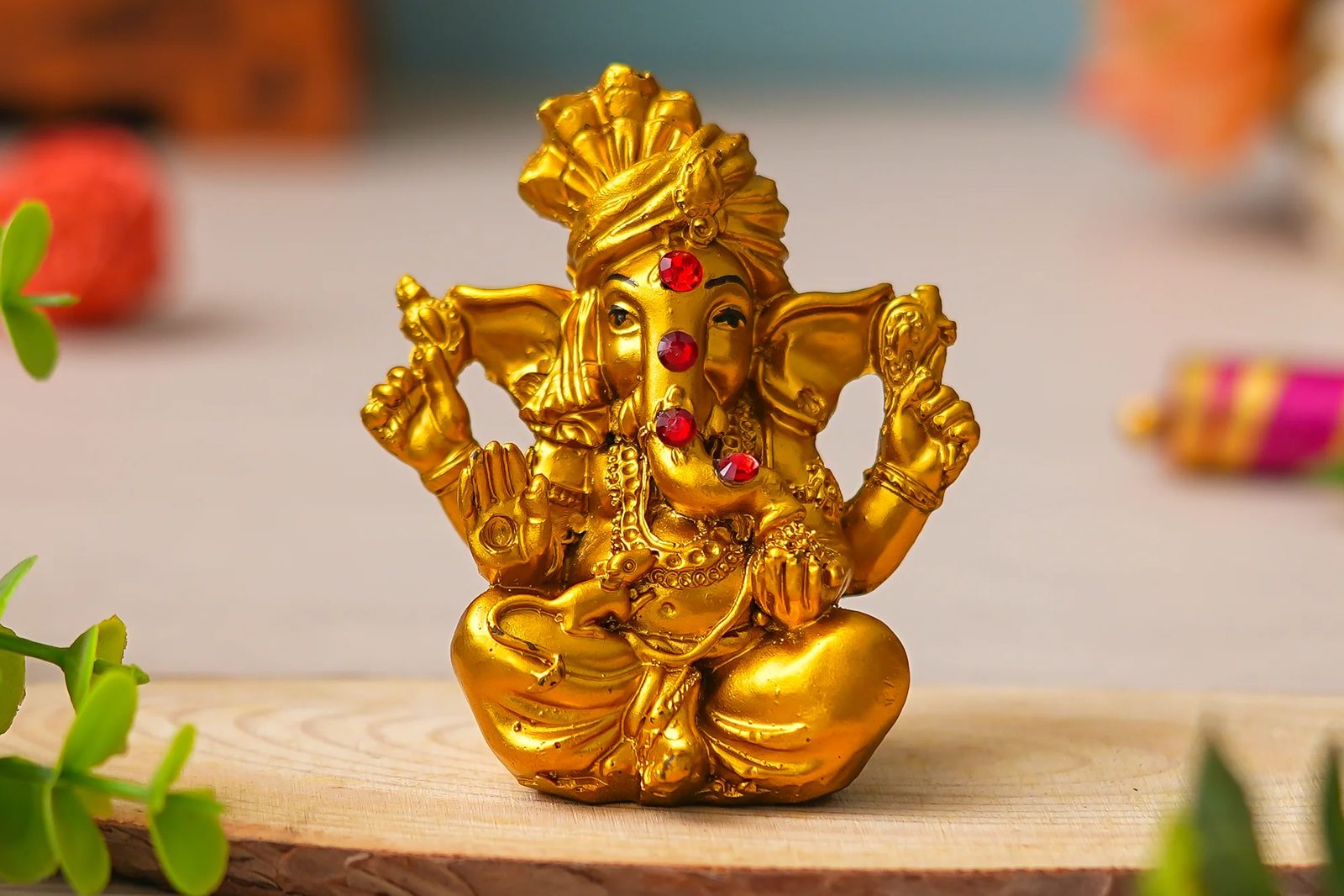 A golden Lord Ganesha idol lit by soft temple light