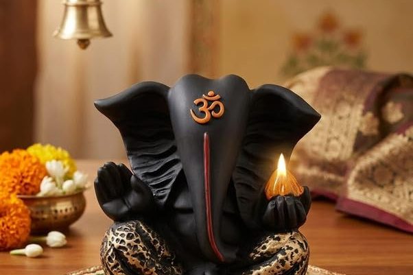 A Lord Ganesha idol arranged with diyas in a warm, devotional setting